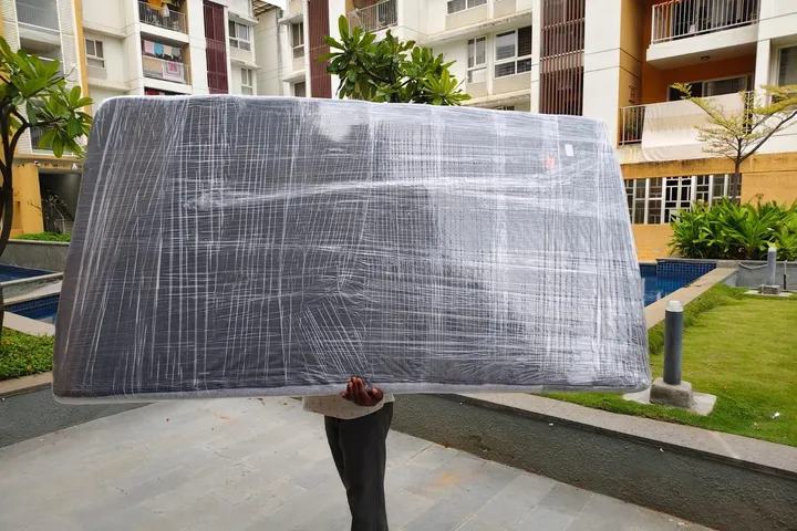 Kerala Road Lines crew bubble-wrapping furniture before loading