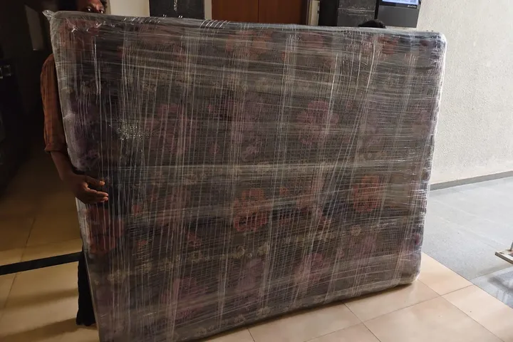 Kerala Road Lines crew handing over a carton at the delivery address