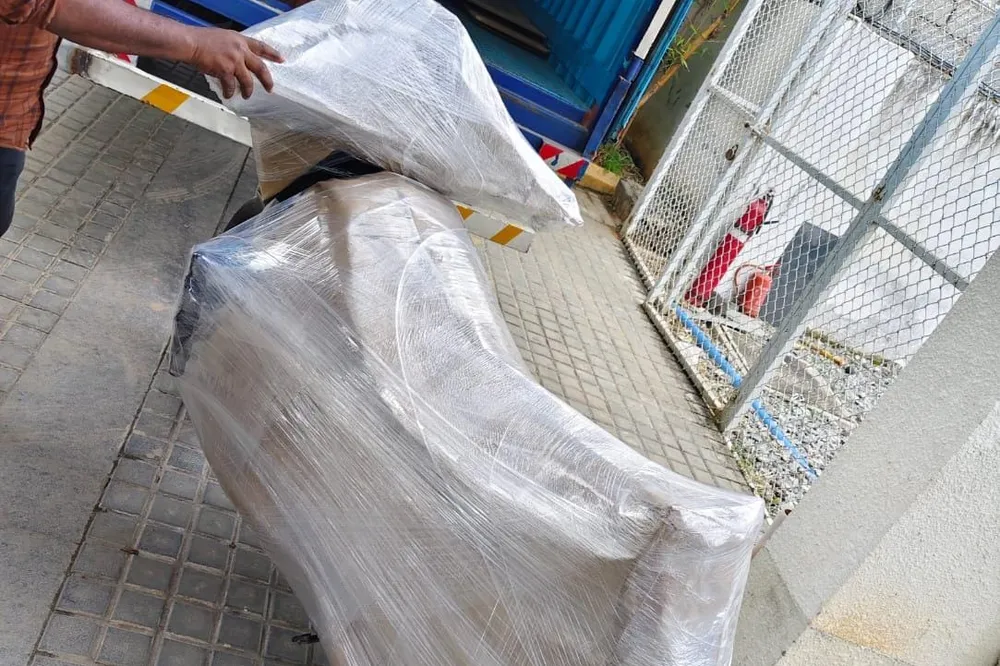 Loading cartons into a Kerala Road Lines truck outside an apartment block